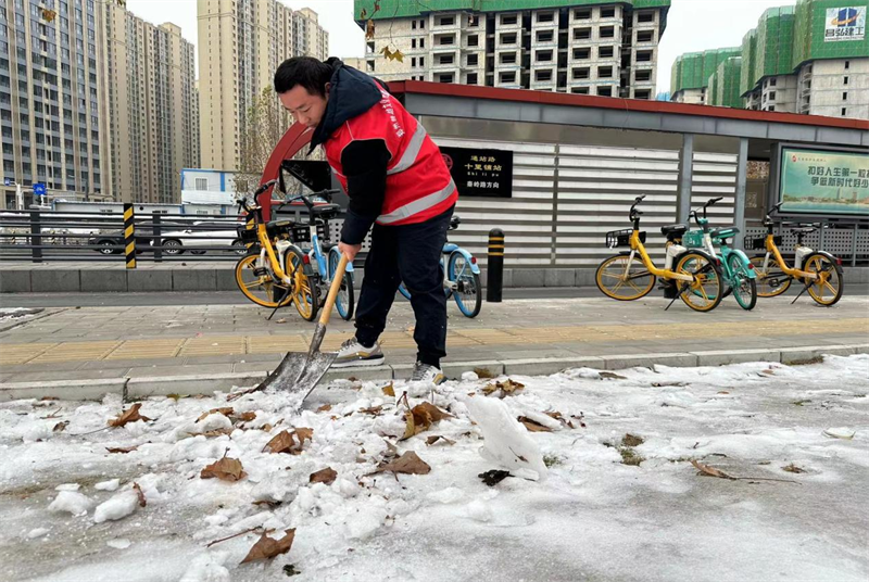 赫喆团支部为公交车站扫冰除雪 保障市民安全出行